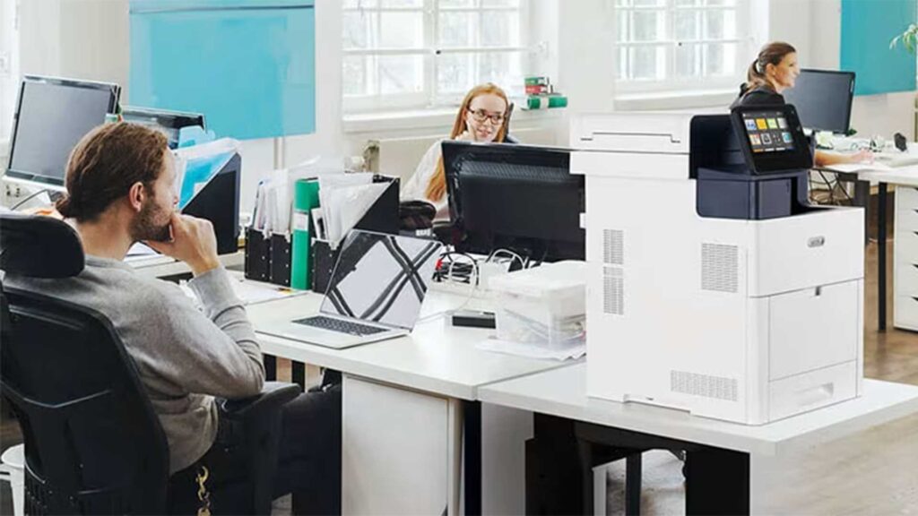 A Xerox printer/copier next to a workstation for employees to use