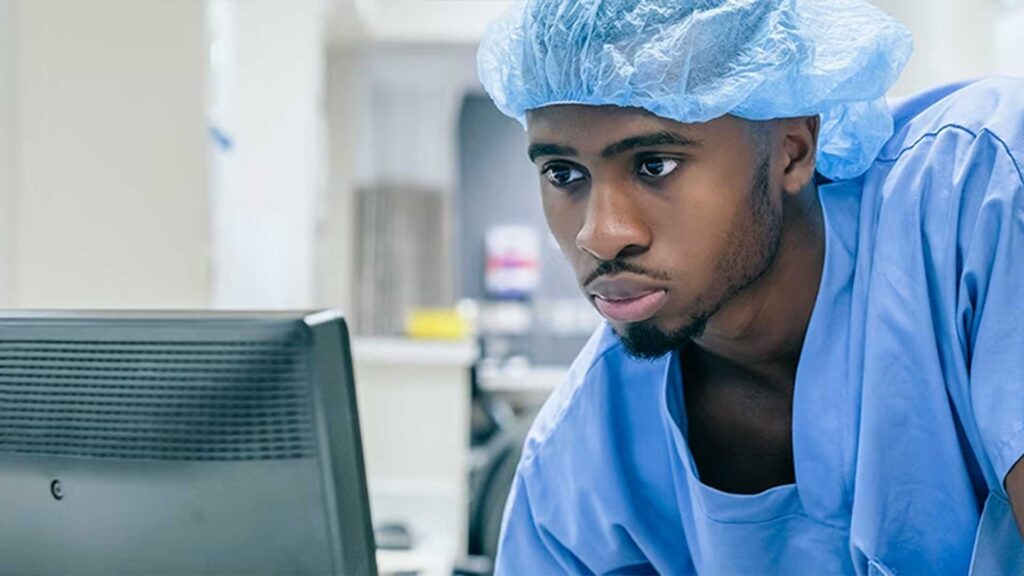 A nurse using a computer to view documents, a part of the HIPAA compliant document solutions at the hospital/clinic