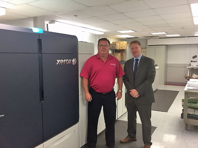 Dan Mcaloon standing next to a Xerox machine